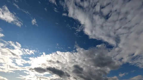 Time lapse: sun rays brake through fluffy clouds flying in the sky. Stock Footage 129269461