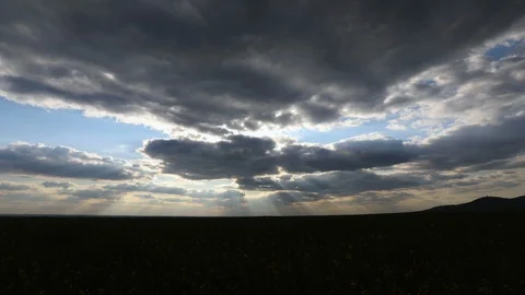 TIME LAPSE of the sun rays break through clouds on vivid blue sky. Видео 129875356