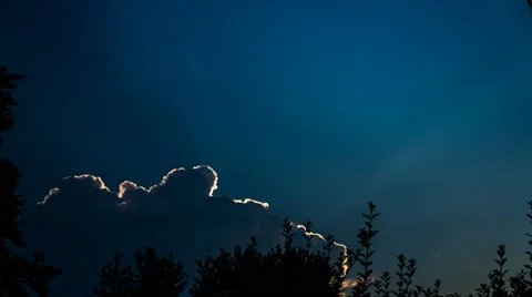 Time Lapse of Sun Rays coming from behind large white cloud during sunrise Stock Footage 66435105