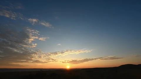 Time lapse of the sun rising above rolling distant hills as summer clouds  Stock Footage 281184874
