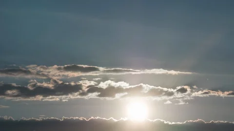 Time lapse. Sun rising between clouds into blue sky Stock Footage 111399798
