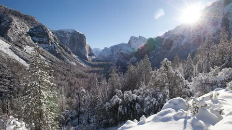 Time lapse of the sun rising in a blue sky above a snow covered Yosemite Valley Stock Footage 145508462