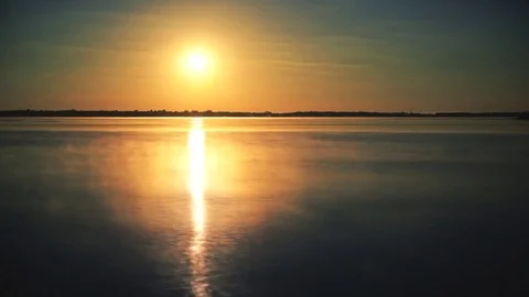 Time lapse of sun rising over water at dawn with morning mist Stock Footage 71140963