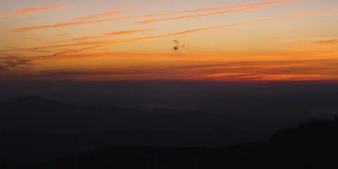 Time-lapse of sun rising over the silhouetted mountain ranges Stock Footage 103397127