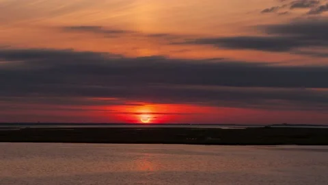 Time lapse of the sun rising over water during a partial solar eclipse. Stock Footage 160155681