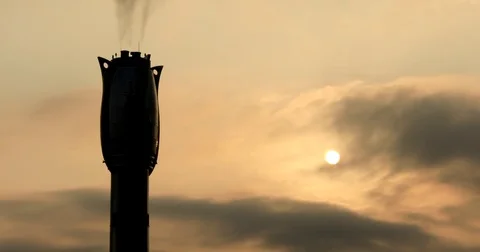 Time lapse of sun rising throug foggy gray clouds behind chimney of factory :4K Stock Footage 73036890