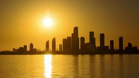 Time lapse of the sun setting behind a silhouetted city skyline Stock Footage 214856610