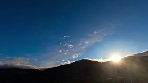 Time lapse of sun setting behind mountains  Video stock 318448958