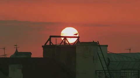 Time lapse of a sun setting down behind roof tops Stock Footage 40877609