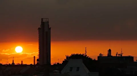 Time lapse of Sun setting down behind tall building silhouette Stock Footage 51876366