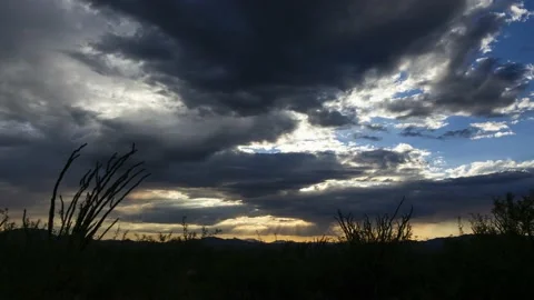 Time lapse of sunrays beaming down from clouds during a colorful sunset Stock Footage 136142456