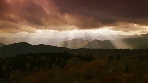 Time-lapse of sunrays falling on the mountain ranges through the dark clouds Stock Footage 103395761