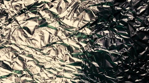 Time lapse sunrise drop shadow on a crumpled foil Video stock 128644910