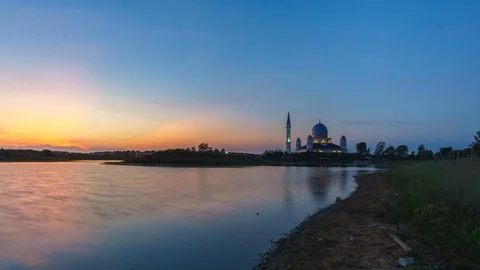 Time lapse of sunrise reflected in calm lake surface with beautiful mosque. Video stock 96127246