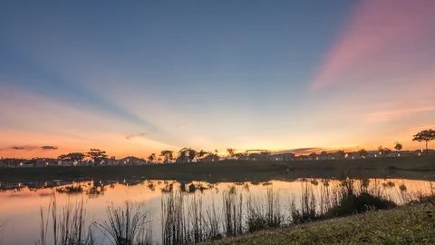 Time-lapse of sunrise with reflections on the lake at Hillpark, Puncak Alam Stock Footage 129864646