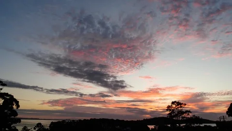 Time lapse of sunrise with scattered clouds and changing colors Video stock 122439879
