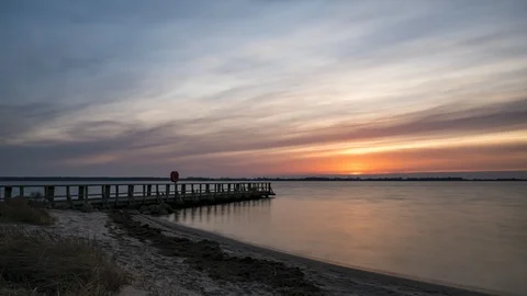Time lapse of sunset at a beautiful beach at the ocean with a footbridge Stock Footage 126164518