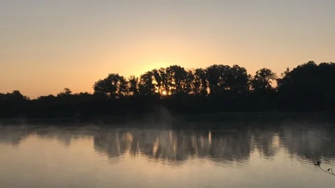 Time-lapse a sunset with bright clouds over the river Stock Footage 106023621
