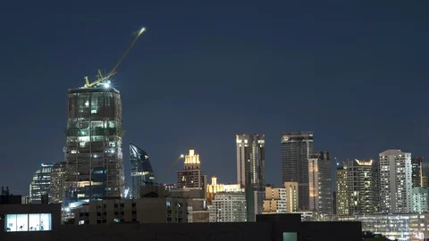 Time lapse of sunset in city with construction crane operating in background. Stock Footage 89229137