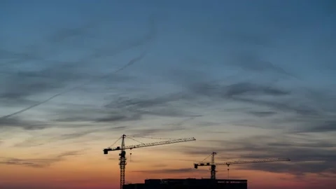 Time Lapse of  Sunset with Clouds and House Roof with  Cranes 스톡 동영상 130529616