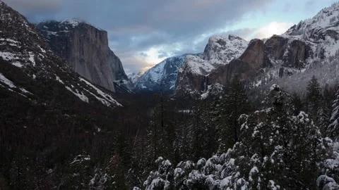 Time lapse of sunset clouds and Yosemite Valley partly covered with melted snow Stock Footage 146238651