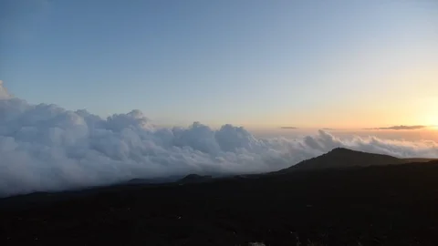 Time Lapse, Sunset with clouds moving above black lava stone and volcano (Mou Stock Footage