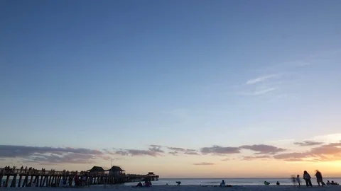 Time Lapse of Sunset Clouds Over Ocean Pier Видео 77072396