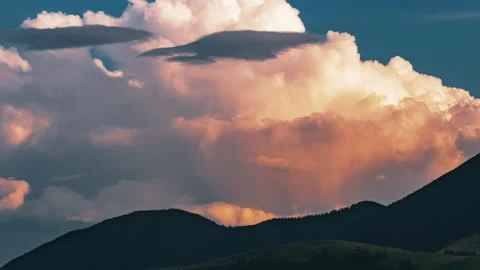 Time lapse of sunset clouds rolling over behind the mountain hills Stock Footage 154574720