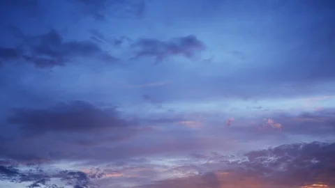Time lapse of sunset colored clouds in the blue sky Stock Footage 110751699