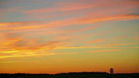 Time-lapse sunset in the field, the sky with clouds turns orange Stock Footage 156131555