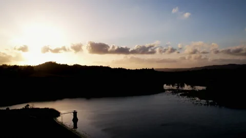 Time lapse of sunset with mountain silhouettes over lake with clouds Video stock 154518517