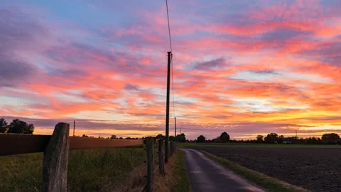 Time lapse of a sunset. An old fence, road and power pole can be seen. Stockbeeldmateriaal 169257352