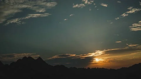 Time lapse of sunset over mountain peaks. Beautiful sky and ray light Stock Footage