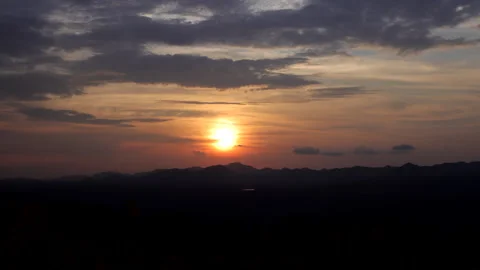 Time-lapse sunset over a mountain with colorful orange clouds Video stock 292594944