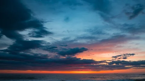 Time lapse at sunset over ocean with dramatic, vivid orange sky and dark clouds Stock Footage 106648632