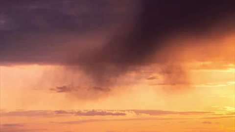 Time lapse. Sunset sky with huge rainy dark gray cloud moving on the orange sky 스톡 동영상 169048745