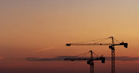Time lapse of sunset sky with silhouettes of moving cranes and workers Stock-Footage 275292910