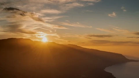 Time lapse sunset, the sun goes behind the mountain, the orange clouds move Stock Footage 125128776