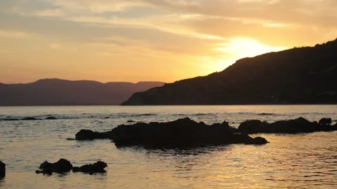 Time lapse of a sunset, sun goes behind the mountain. Stock Footage 199601142