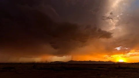 Time Lapse of sunset with sun, rain, lightning and blowing dust 스톡 동영상 102870875