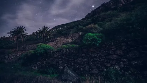 Time-Lapse of Tent at Mountain Base with Flickering Lights, Starry Sky, and Fast Stock Footage 315099629