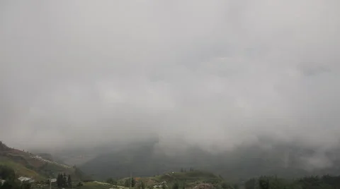 Time lapse of the thick clouds moving between the mountains Stock Footage 50358295