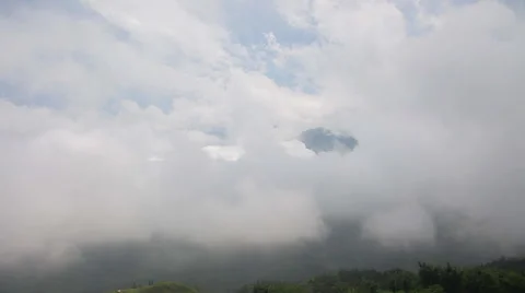 Time lapse of the thick clouds moving between the mountains Stock Footage 50358338