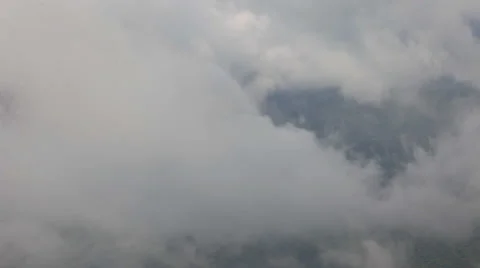 Time lapse of the thick clouds moving between the mountains Stock Footage 50358363