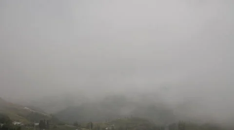 Time lapse of the thick clouds moving between the mountains Stock Footage 50358580