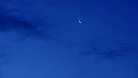 Time-lapse of thin crescent moon in the blue sky Stock Footage 103785638