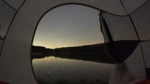 Time lapse through a tent at night with the Milky Way rising over a Lake Stockbeeldmateriaal 154382765