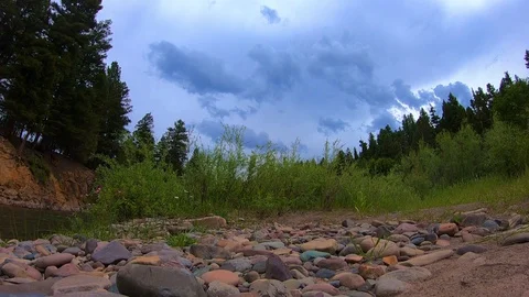 Time lapse of thunder clouds rolling in over a river. Stock Footage 128956419