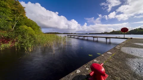 Time lapse of a timber lake pier in the foreground and castle ruin island with 動画素材 331079642