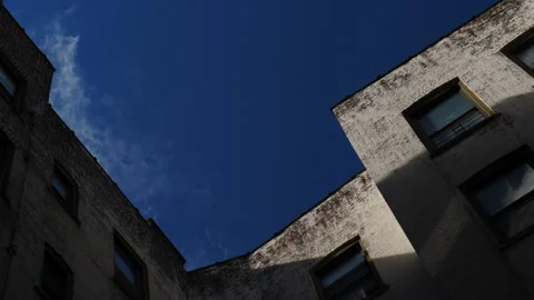 Time lapse top corner of a brick building with Cumulus clouds flying by Stock Footage 136716829